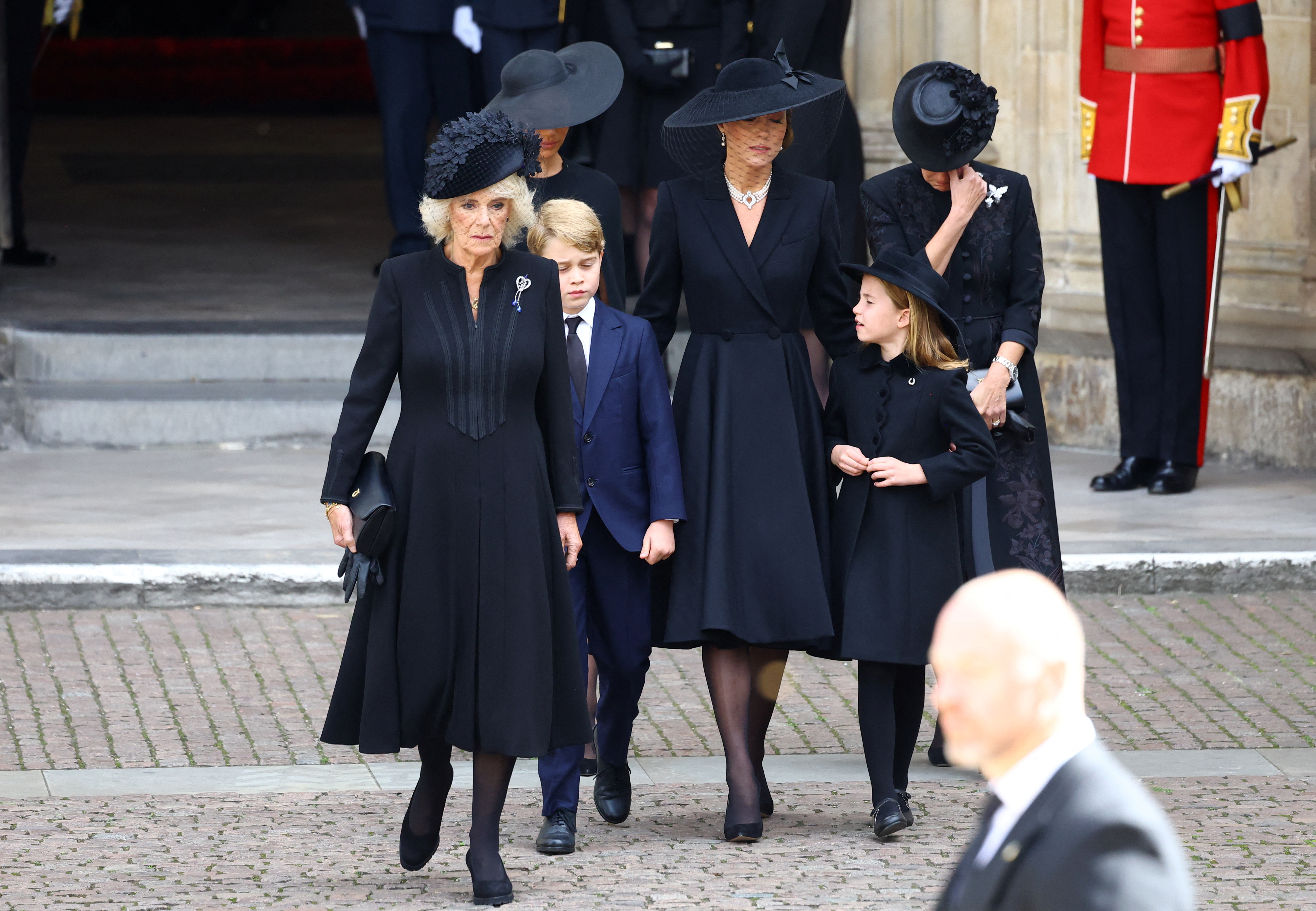 LONDON, ENGLAND - SEPTEMBER 19:  Queen Camilla, Prince George, Princess Charlotte, Catherine, Princess of Wales, Meghan, Duchess of Sussex, and Sophie, Countess of Wessex walk after a service at Westminster Abbey on the day of the state funeral and burial of  Queen Elizabeth, on September 19, 2022 in London, England. (Photo by Hannah McKay - WPA Pool/Getty Images)