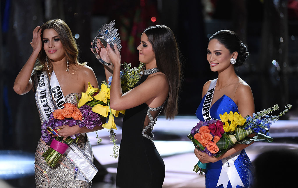 Miss Colombia 2015, Ariadna Gutiérrez Arévalo, mira como Miss Universo 2014 Paulina Vega se quita la corona para entregársela a Miss Filipinas 2015.