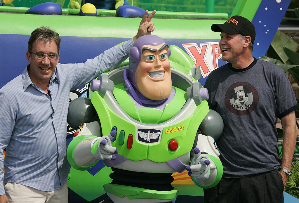 El actor Tim Allen (izq.) y el director ejecutivo de Walt Disney Company, Michael Eisner (der.), hacen payasadas con el personaje de Disney, Buzz Lightyear, en la inauguración oficial de la atracción "Buzz Lightyear Astro Blasters" en el avance de prensa y invitados especiales del 50.º aniversario. día en Disneylandia en Anaheim, California.