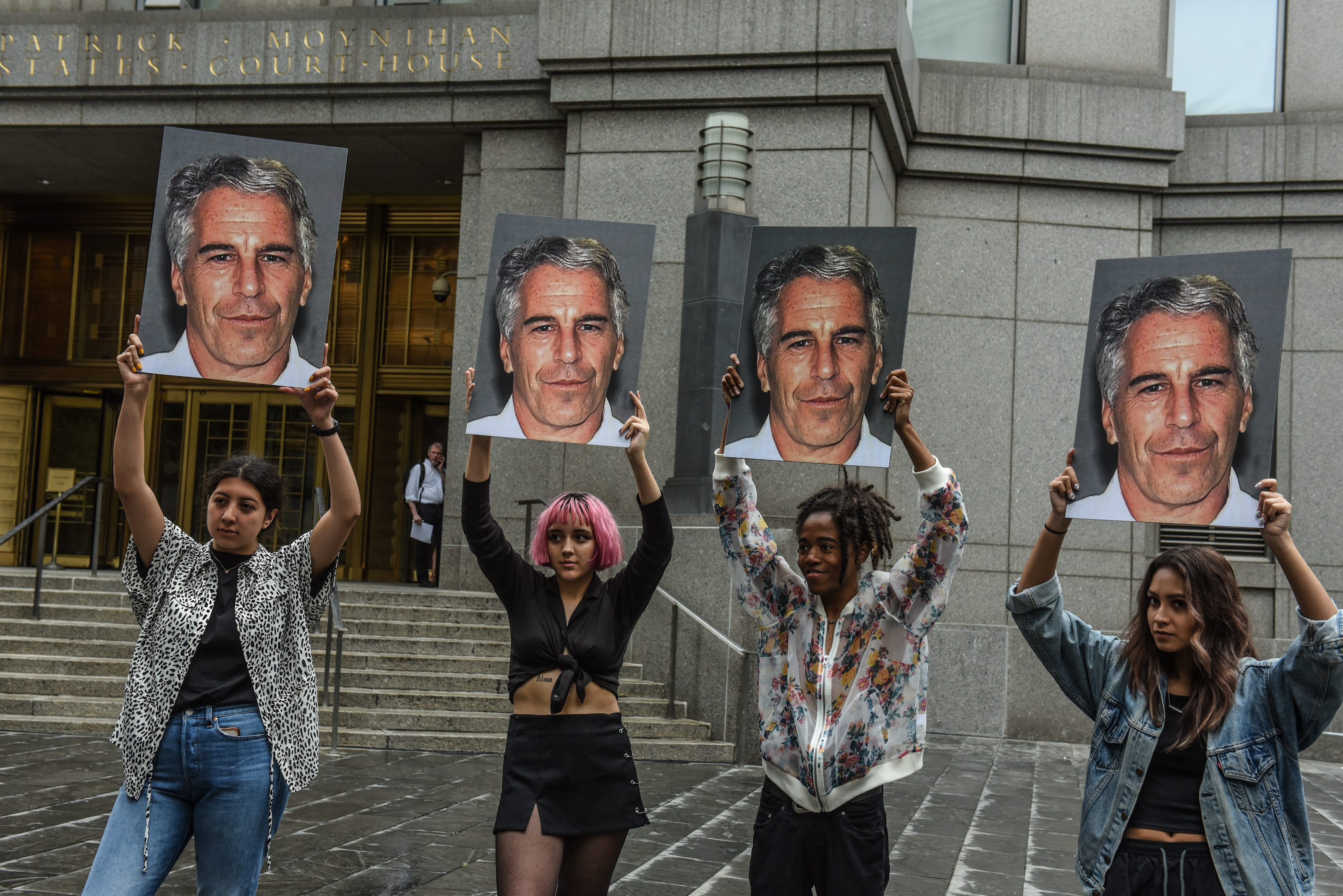 Un grupo de protesta llamado "Hot Mess" sostiene carteles de Jeffrey Epstein y el presidente Donald Trump frente al tribunal federal en la ciudad de Nueva York.