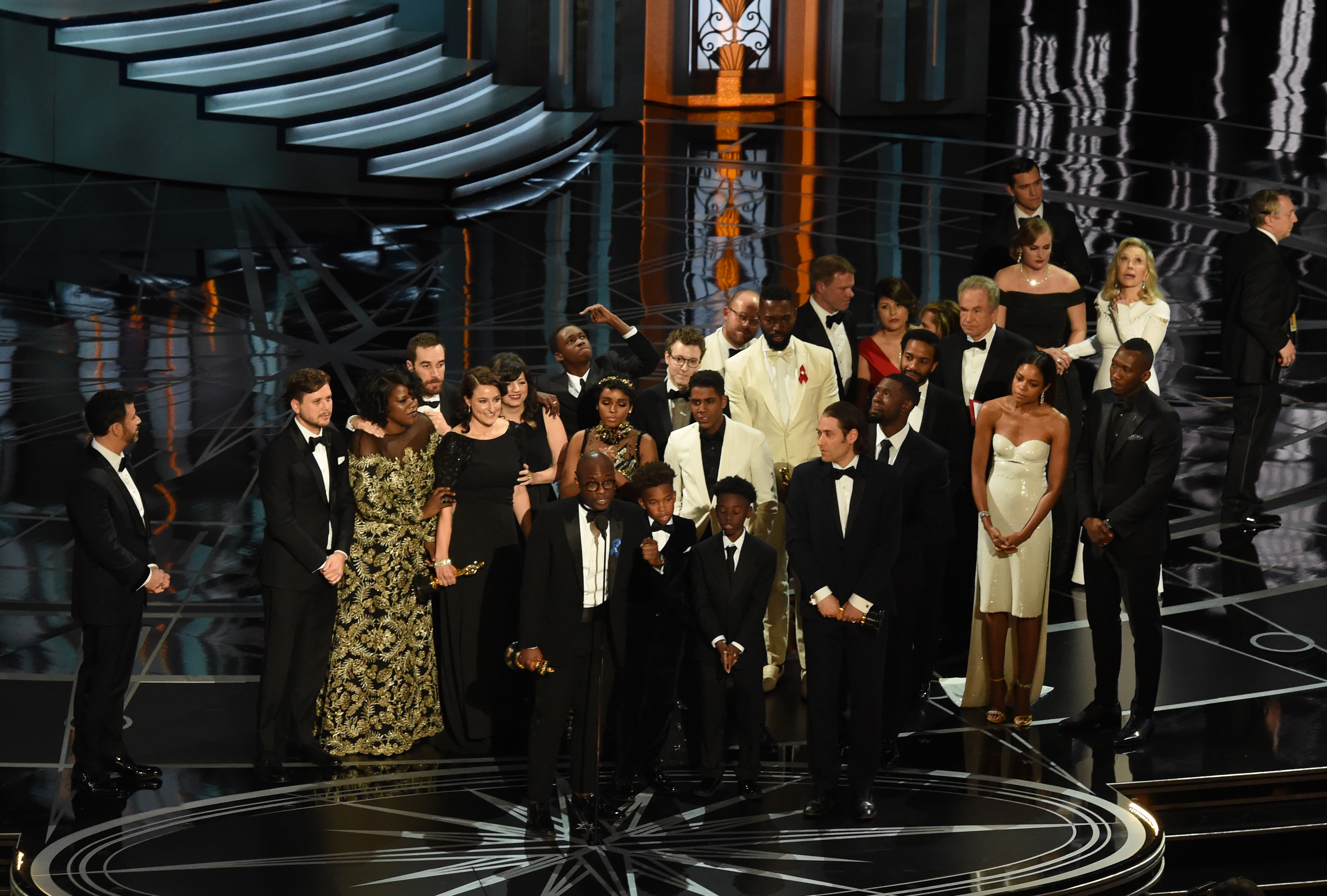 US director Barry Jenkins (C) speaks after "Moonlight" won the Best Film award as Host Jimmy Kimmel (L) looks on at the 89th Oscars on February 26, 2017 in Hollywood, California. / AFP / Mark RALSTON        (Photo credit should read MARK RALSTON/AFP via Getty Images)