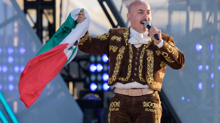 Lupillo Rivera en uno de sus conciertos mostrando la bandera de México.