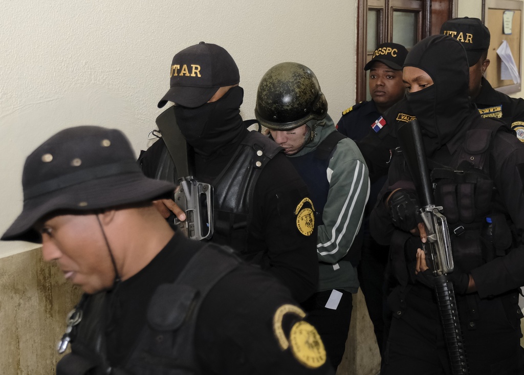 El rapero Daniel Hernández, conocido como Tekashi 6ix9ine, es escoltado por la policía a un área diferente del tribunal, el Palacio de Justicia, en Santo Domingo, República Dominicana, el jueves 25 de enero de 2024.