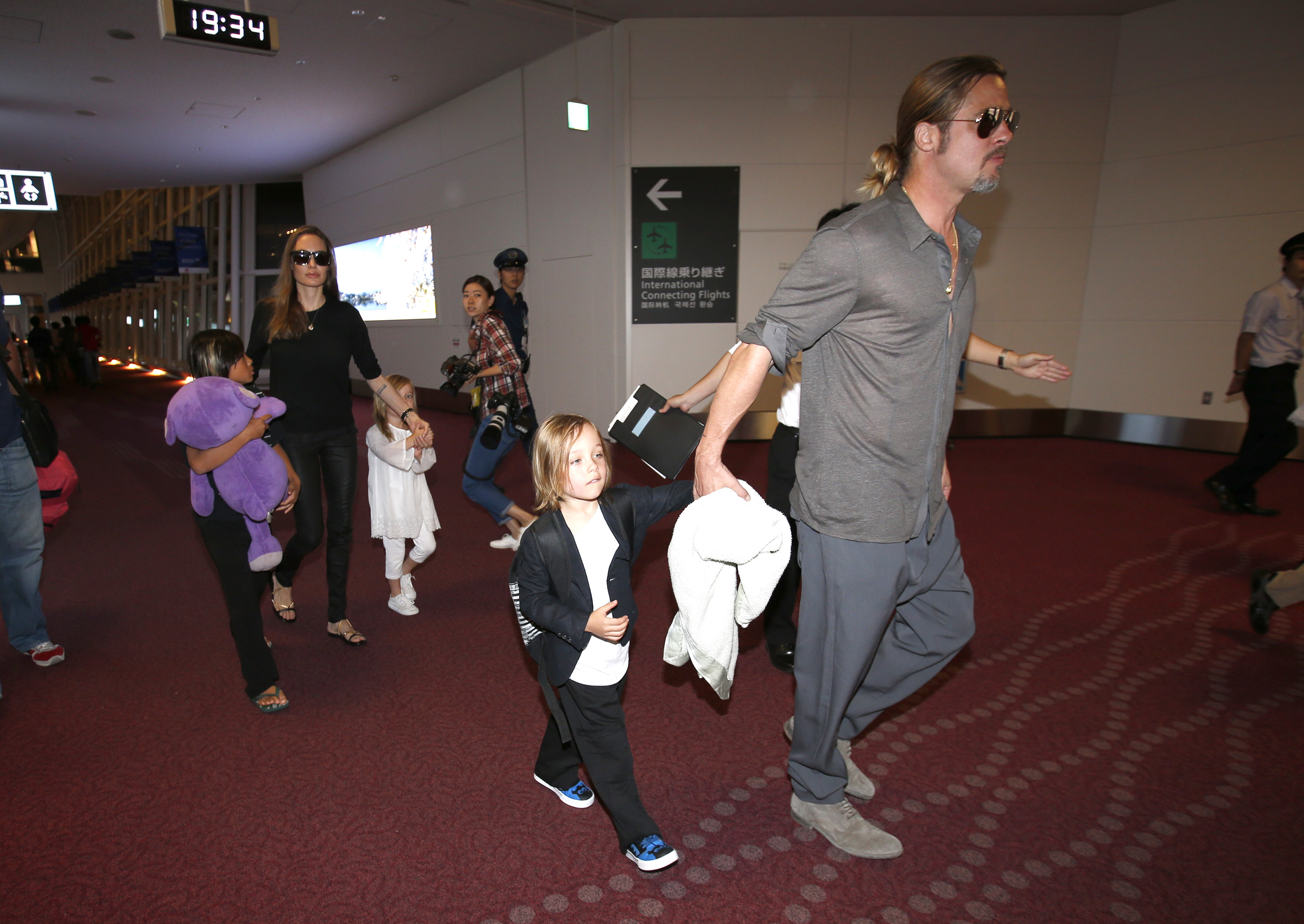 Brad Pitt y Angelina Jolie junto con sus hijos llegan al aeropuerto internacional de Haneda en Tokio, el 28 de julio de 2013.