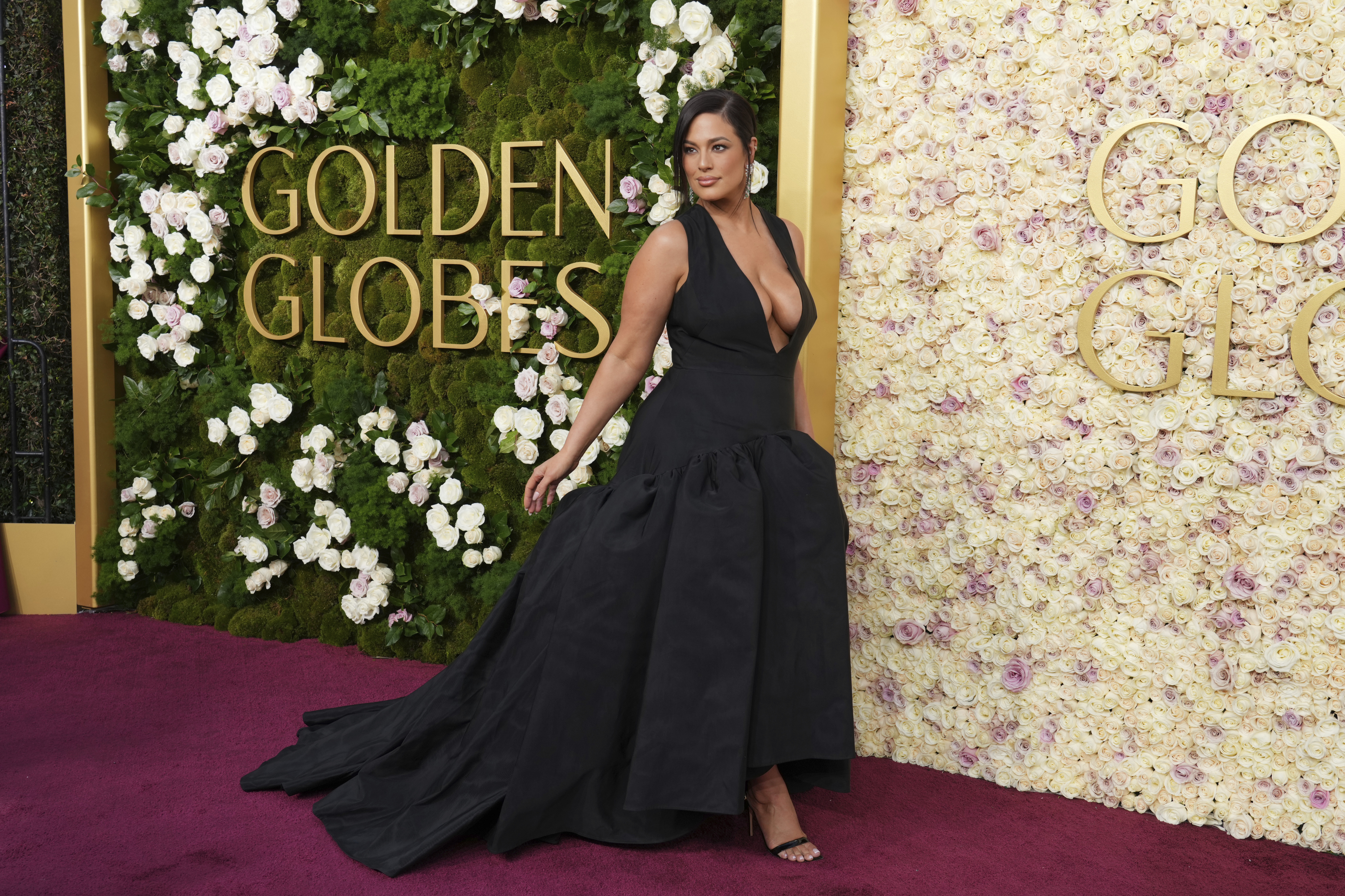 Ashley Graham deslumbra en los Golden Globe 2025 con un vestido negro escotado y voluminoso, combinando sensualidad y elegancia.