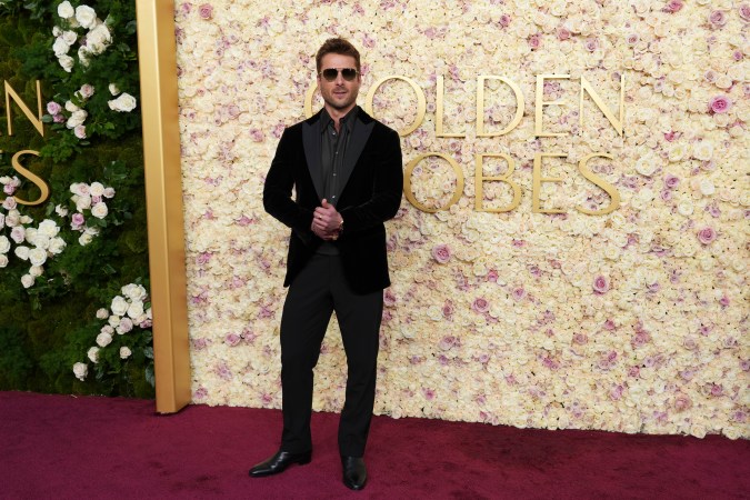 Glenn Powell sorprende con elegancia en los Golden Globe 2025, luciendo una chaqueta de terciopelo marrón oscuro y destacando su estilo moderno.