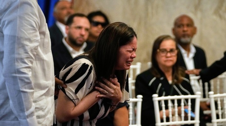 Zulinka (centro), hija del cantante dominicano Rubby Pérez, quien falleció al derrumbarse el techo del club nocturno Jet Set durante su concierto de merengue, llora durante su velorio en el Teatro Nacional Eduardo Brito en Santo Domingo, República Dominicana, el jueves 10 de abril de 2025. (Foto AP/Matias Delacroix).